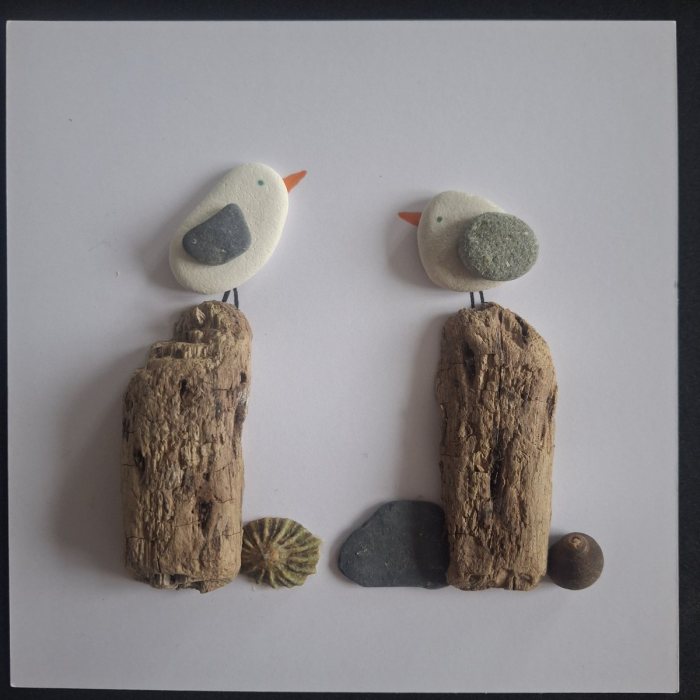 Weathered Posts: two white pebble gulls on dark driftwood posts