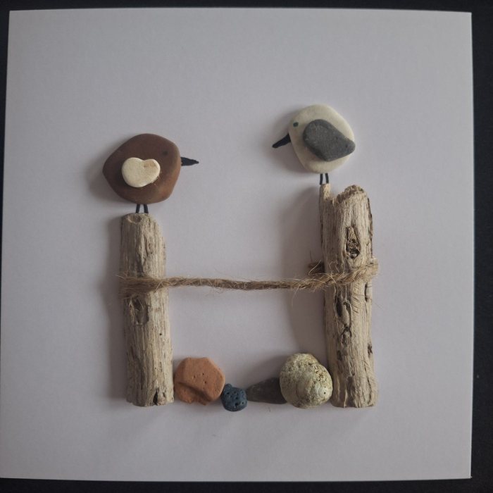 Over the Rope: a russet pebble bird and a pale pebble bird on posts joined by rope