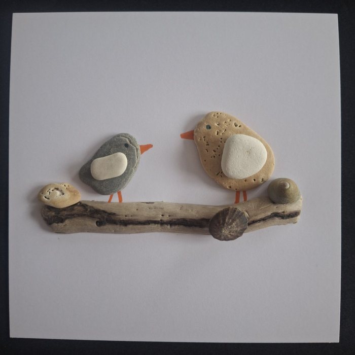 Branch Natter: a grey pebble bird and a honey-coloured pebble bird on a driftwood branch